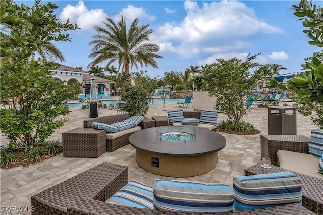 view of patio with a community pool and a fire pit