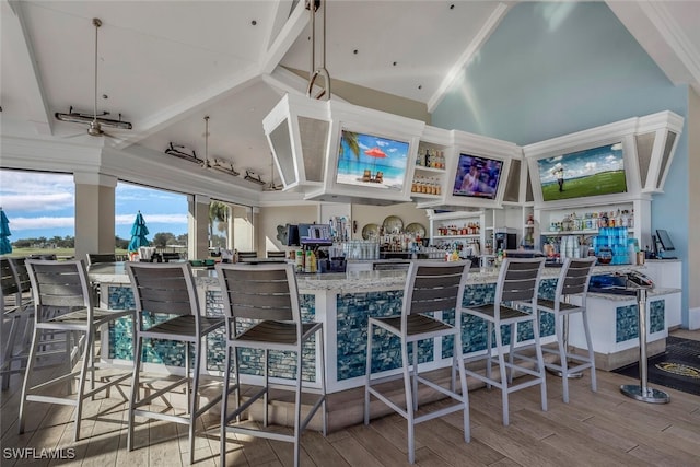 dining space with high vaulted ceiling and wood finished floors