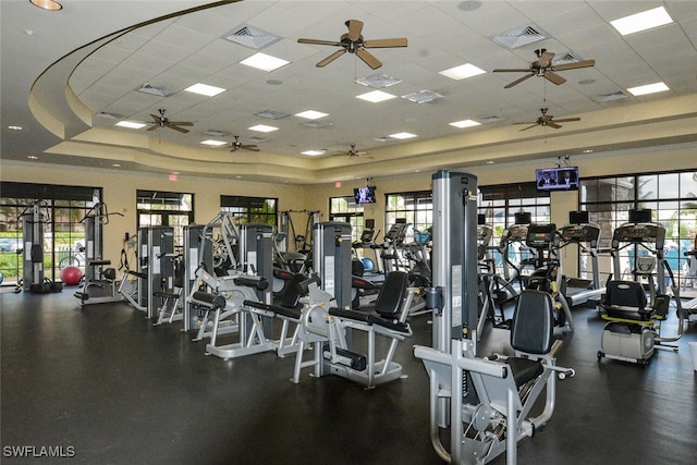 workout area featuring a raised ceiling, a ceiling fan, and visible vents