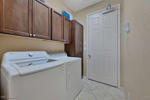 8945 Malibu St Unit 204, Naples, FL 34113 - laundry area with independent washer and dryer, cabinet space, a textured wall, baseboards, and light tile patterned floors