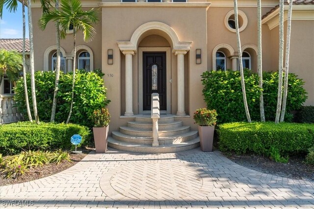 550 21st Ave S, Naples, FL 34102 - doorway to property featuring stucco siding