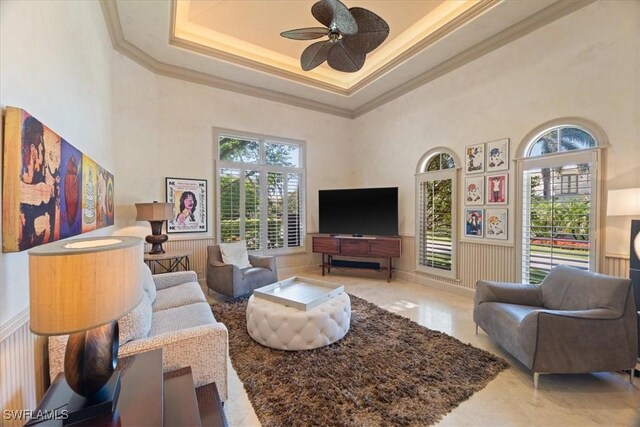 550 21st Ave S, Naples, FL 34102 - living area with a wainscoted wall, crown molding, a high ceiling, and a ceiling fan