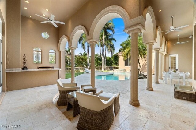 550 21st Ave S, Naples, FL 34102 - outdoor pool with an outdoor kitchen, a patio, fence, and a ceiling fan