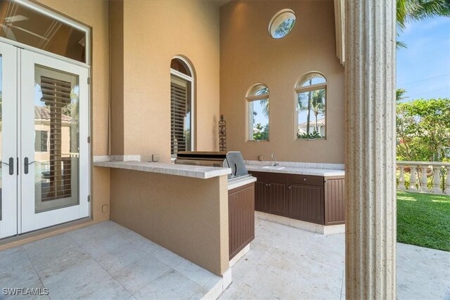 550 21st Ave S, Naples, FL 34102 - view of patio featuring a sink, exterior kitchen, and french doors