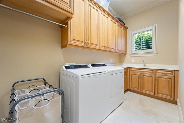 550 21st Ave S, Naples, FL 34102 - washroom with a sink, cabinet space, light floors, crown molding, and washing machine and dryer