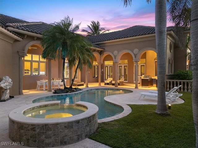 550 21st Ave S, Naples, FL 34102 - view of swimming pool featuring a pool with connected hot tub, a patio area, french doors, and a lawn
