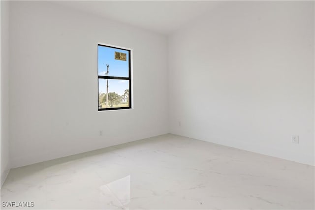 spare room featuring marble finish floor