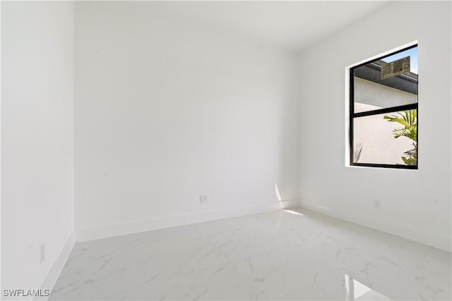 empty room with baseboards and marble finish floor