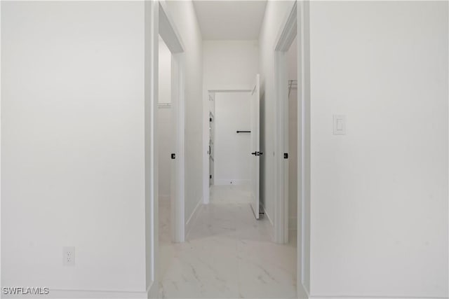 corridor featuring baseboards and marble finish floor