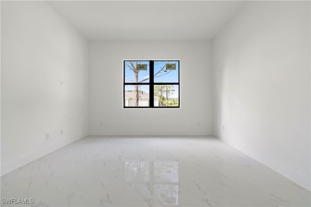 empty room with baseboards and marble finish floor
