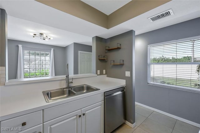 26672 Little John Ct Unit 85, Bonita Springs, FL 34135 - kitchen featuring stainless steel dishwasher, a sink, light tile patterned floors, light countertops, and white cabinetry