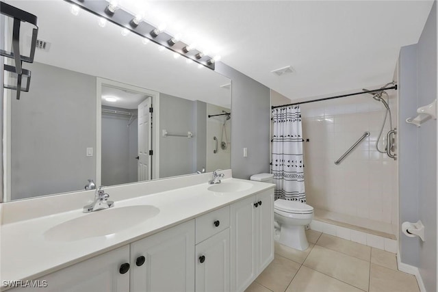 26672 Little John Ct Unit 85, Bonita Springs, FL 34135 - bathroom featuring toilet, a tile shower, double vanity, tile patterned flooring, and a walk in closet