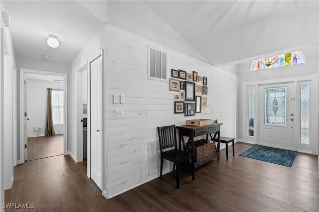 foyer with plenty of natural light, visible vents, dark wood-style flooring, and vaulted ceiling
