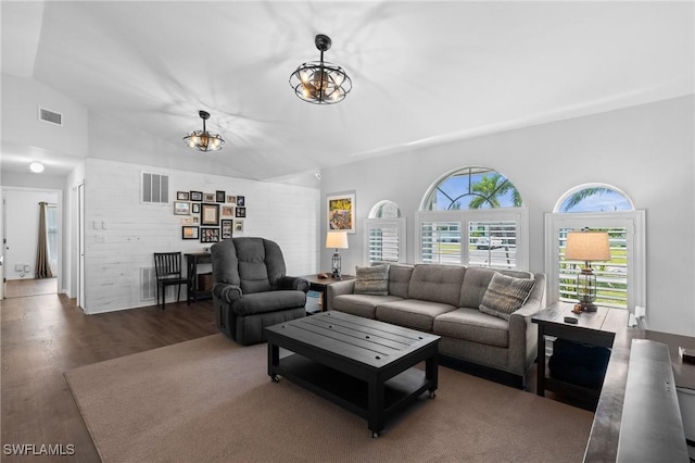 living room with wood finished floors, vaulted ceiling, and visible vents