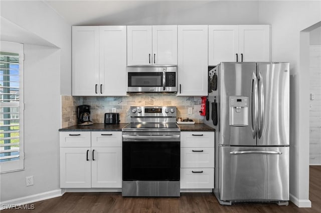 kitchen with tasteful backsplash, white cabinetry, dark countertops, dark wood finished floors, and appliances with stainless steel finishes