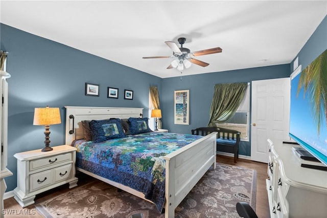 bedroom with a ceiling fan, baseboards, and dark wood-style floors