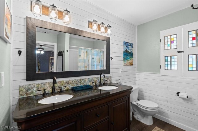1511 SW 29th Ter, Cape Coral, FL 33914 - bathroom with wooden walls, double vanity, wood finished floors, wainscoting, and a shower with shower curtain