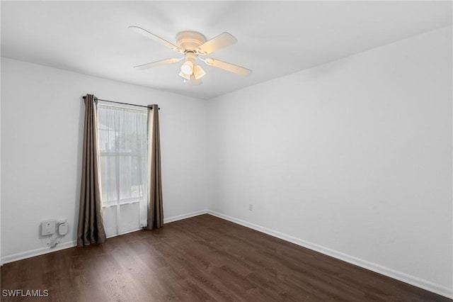 empty room with dark wood-style flooring, baseboards, and ceiling fan