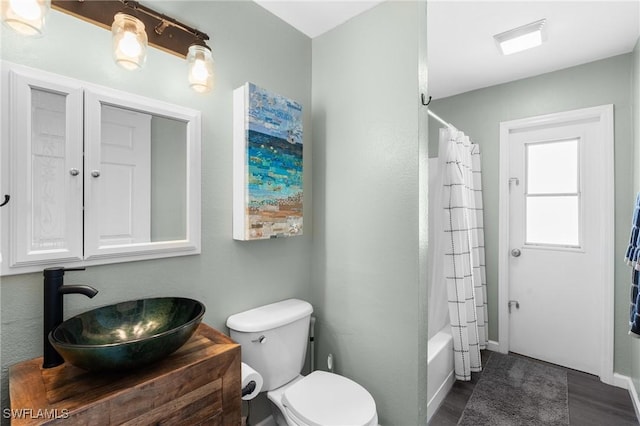 bathroom featuring toilet, shower / bathtub combination with curtain, and vanity