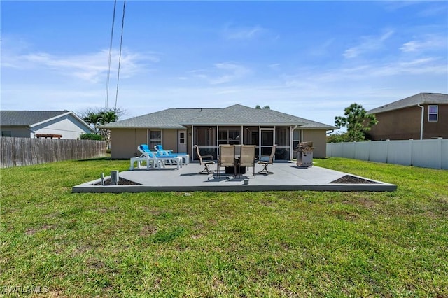 back of house with a patio area, a fenced backyard, a yard, and a sunroom