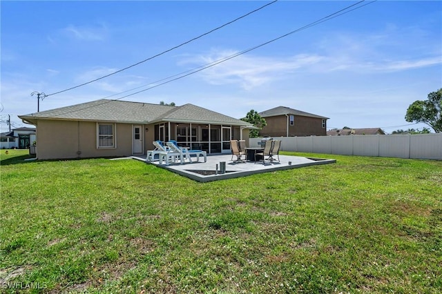 back of house with a patio, stucco siding, fence, a yard, and a sunroom