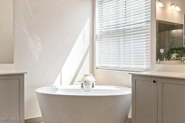 full bath featuring a freestanding tub, vanity, and a tile shower