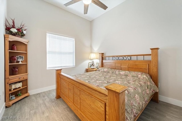 bedroom with light wood-style flooring, baseboards, and ceiling fan