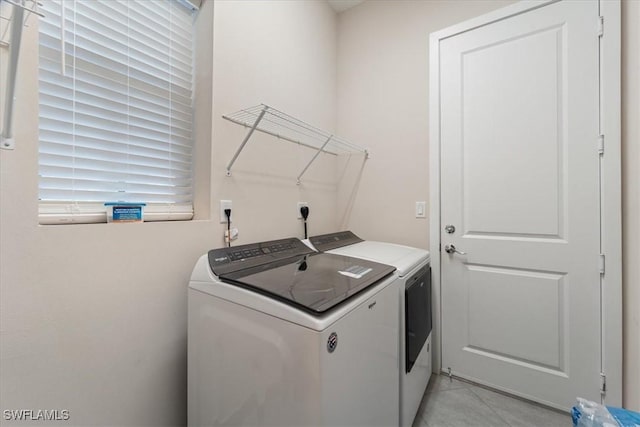 laundry area with light tile patterned flooring, laundry area, and washing machine and clothes dryer