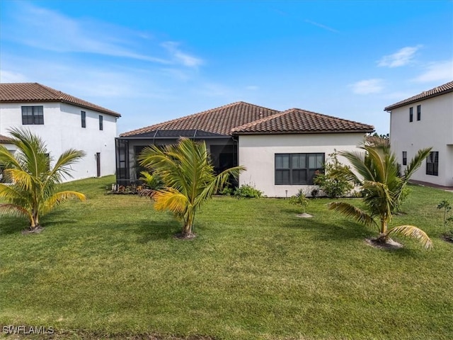 view of front of property with a front yard, stucco siding, a lanai, and a tile roof