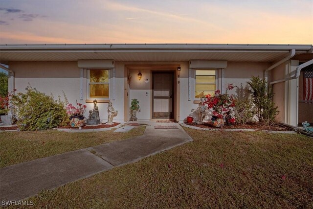 25068 Harborview Rd Unit 1B, Punta Gorda, FL 33980 - view of front of home featuring stucco siding and a front yard