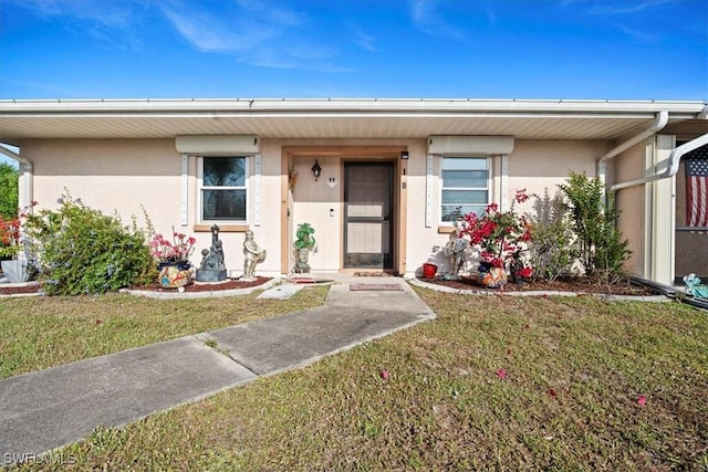 25068 Harborview Rd Unit 1B, Punta Gorda, FL 33980 - view of front facade featuring a front yard and stucco siding