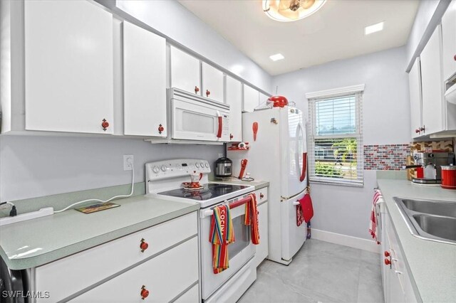 25068 Harborview Rd Unit 1B, Punta Gorda, FL 33980 - kitchen featuring light countertops, white cabinets, baseboards, and white appliances