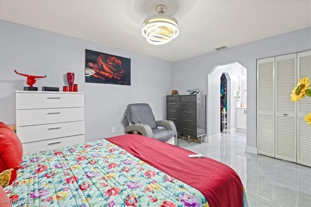 25068 Harborview Rd Unit 1B, Punta Gorda, FL 33980 - bedroom with arched walkways, a textured ceiling, visible vents, and a closet