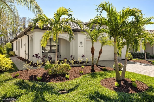 11555 Golden Oak Ter, Fort Myers, FL 33913 - exterior space with driveway, stucco siding, a tiled roof, and an attached garage