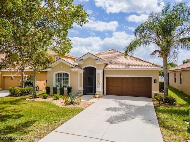 mediterranean / spanish-style house with stucco siding, a front lawn, driveway, and an attached garage