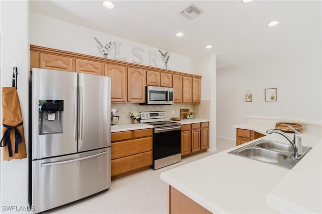 kitchen with tasteful backsplash, appliances with stainless steel finishes, light countertops, a sink, and visible vents