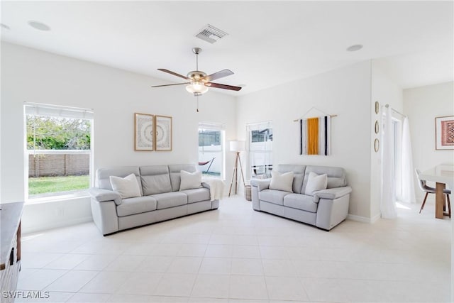 living room featuring light tile patterned floors, visible vents, and a ceiling fan