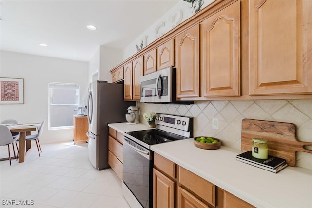 kitchen with recessed lighting, stainless steel appliances, light tile patterned floors, light countertops, and backsplash