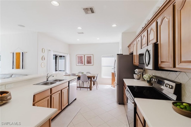kitchen with a sink, visible vents, stainless steel appliances, and light countertops