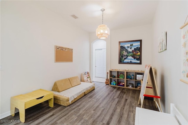 sitting room with arched walkways, wood finished floors, and baseboards