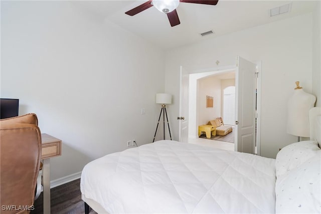 bedroom featuring a ceiling fan, visible vents, baseboards, and dark wood-type flooring