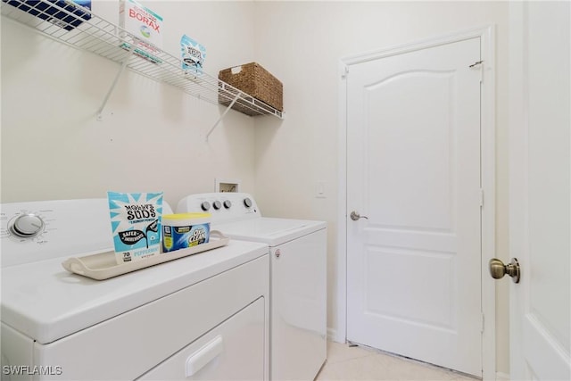 laundry room featuring light tile patterned floors, laundry area, and washing machine and dryer