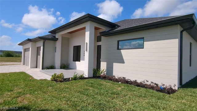 308 SW 13th Ct, Cape Coral, FL 33991 - exterior space with an attached garage and a lawn