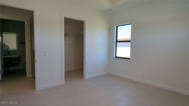 308 SW 13th Ct, Cape Coral, FL 33991 - unfurnished bedroom featuring a spacious closet, baseboards, and a closet