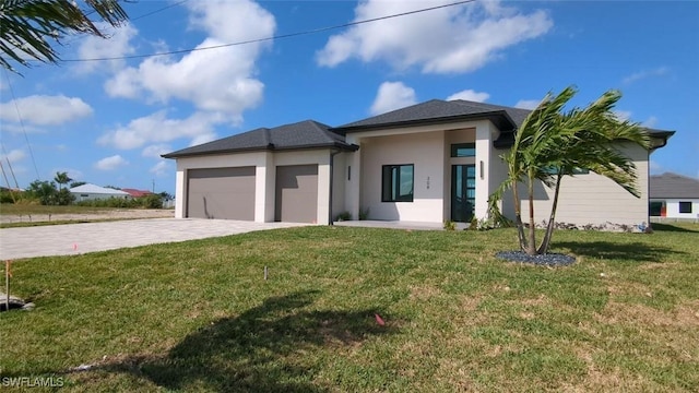 308 SW 13th Ct, Cape Coral, FL 33991 - prairie-style home with a front yard, stucco siding, decorative driveway, and an attached garage