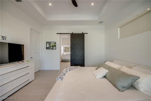 308 SW 13th Ct, Cape Coral, FL 33991 - bedroom featuring a barn door, a raised ceiling, recessed lighting, and ensuite bath