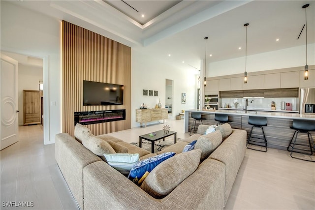 308 SW 13th Ct, Cape Coral, FL 33991 - living area with a towering ceiling, recessed lighting, light wood-style flooring, and a glass covered fireplace