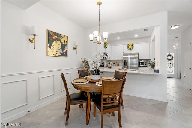 2926 Citrus St, Naples, FL 34120 - dining area featuring a chandelier and light tile patterned floors