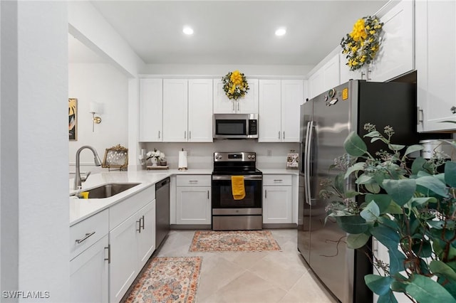 2926 Citrus St, Naples, FL 34120 - kitchen featuring appliances with stainless steel finishes, a sink, light countertops, white cabinetry, and recessed lighting