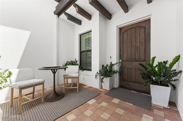 doorway to property featuring stucco siding